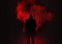 silhouette of man standing against black and red background